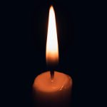 Candlelight in darkness symbolizing awareness as the first step.
